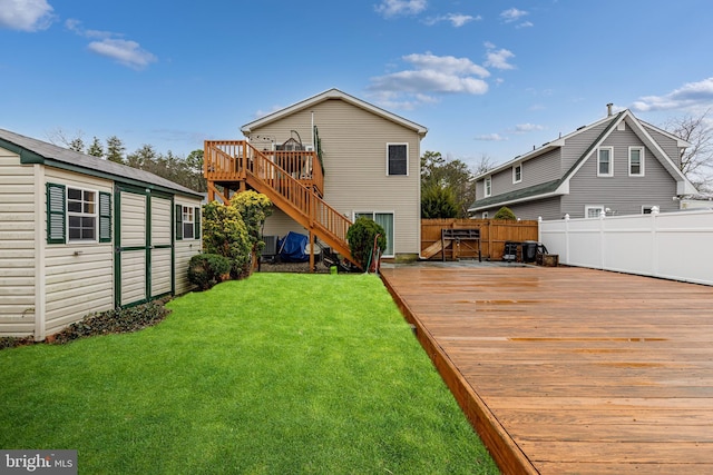 rear view of house featuring a lawn and a deck