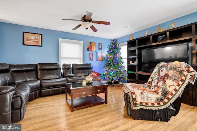 living room with light wood-type flooring and ceiling fan