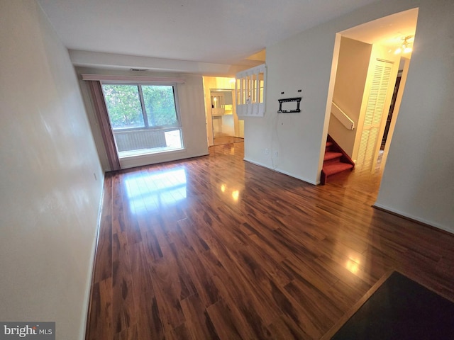 unfurnished living room with dark hardwood / wood-style flooring