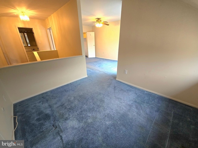 empty room featuring ceiling fan and dark carpet