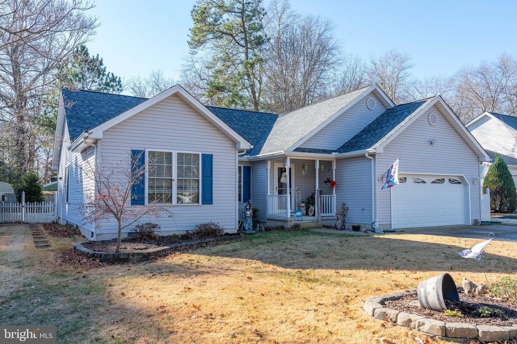 ranch-style house featuring a porch, a garage, and a front yard