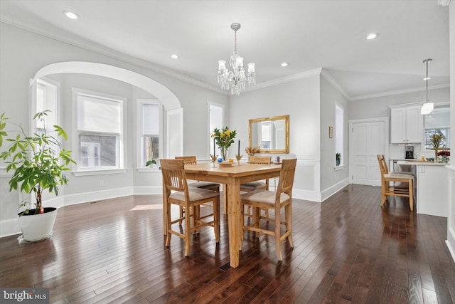 dining space with a notable chandelier, dark hardwood / wood-style flooring, and crown molding