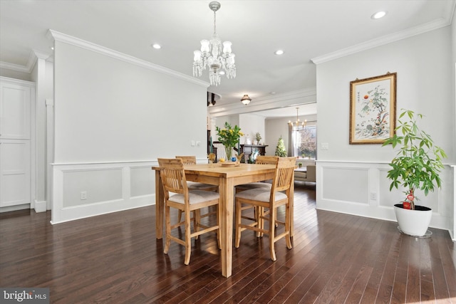 dining room with ornamental molding, dark hardwood / wood-style flooring, and a notable chandelier