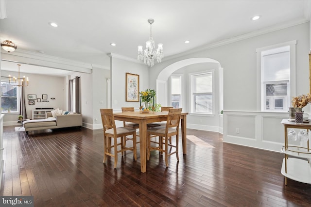 dining space with crown molding, dark hardwood / wood-style flooring, and a notable chandelier