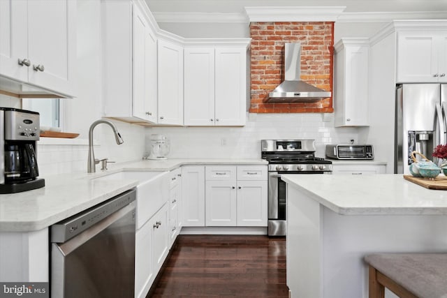 kitchen featuring white cabinets, wall chimney exhaust hood, decorative backsplash, and stainless steel appliances