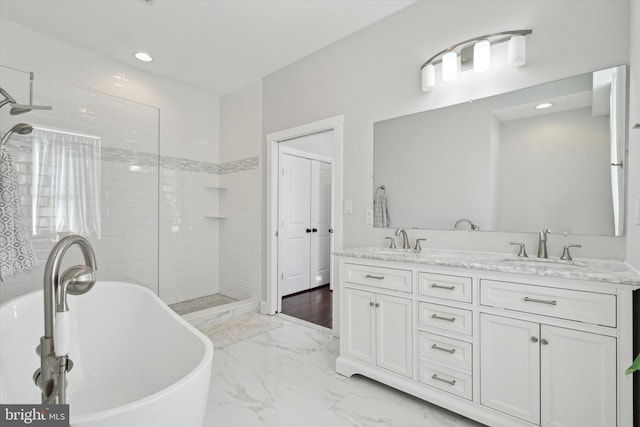 bathroom featuring vanity and independent shower and bath