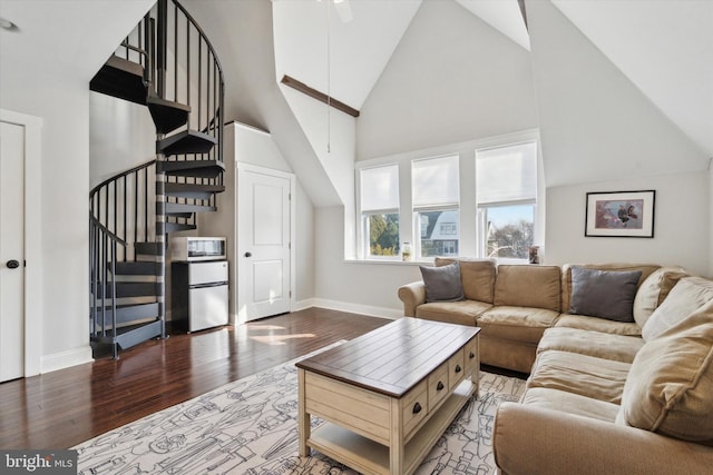 living room featuring a towering ceiling and wood-type flooring