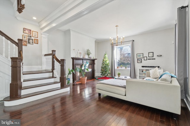 living room featuring dark hardwood / wood-style flooring, a notable chandelier, and ornamental molding