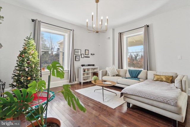 living room with a notable chandelier and dark wood-type flooring