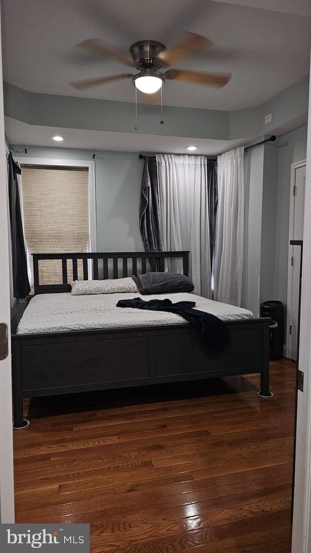 bedroom with ceiling fan and dark wood-type flooring