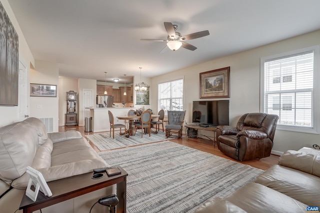 living room with ceiling fan and light wood-type flooring