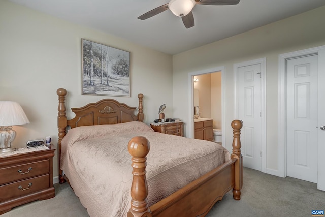 carpeted bedroom with ensuite bathroom and ceiling fan