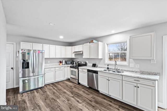 kitchen with sink, dark hardwood / wood-style flooring, light stone counters, white cabinetry, and stainless steel appliances