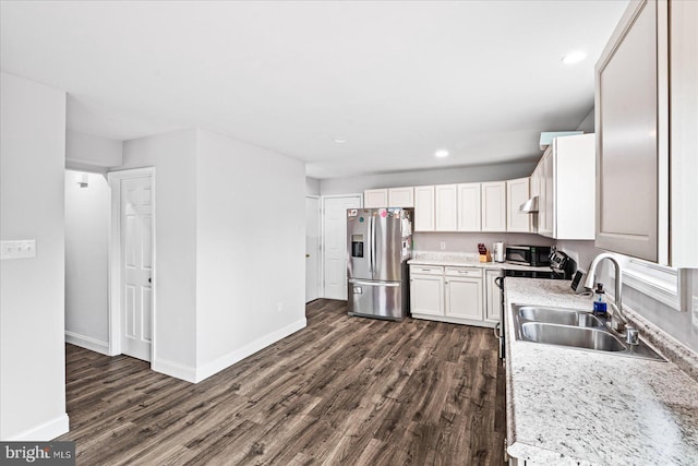 kitchen featuring light stone countertops, sink, dark wood-type flooring, stainless steel fridge with ice dispenser, and white cabinets