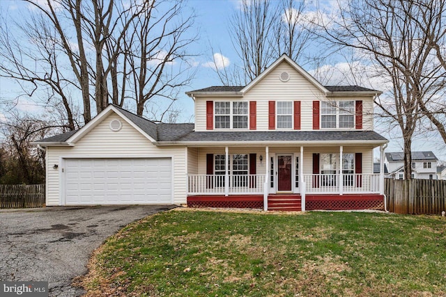 view of front of home featuring a porch, a garage, and a front yard