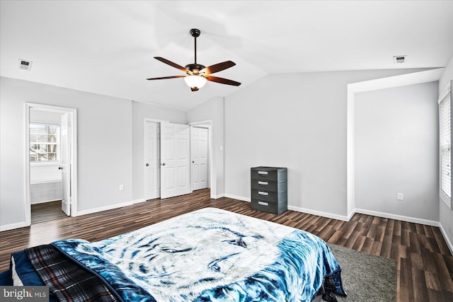 bedroom featuring ceiling fan, dark wood-type flooring, ensuite bathroom, and vaulted ceiling