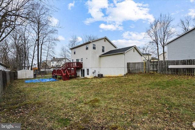 rear view of house featuring a lawn, central air condition unit, a shed, and a deck