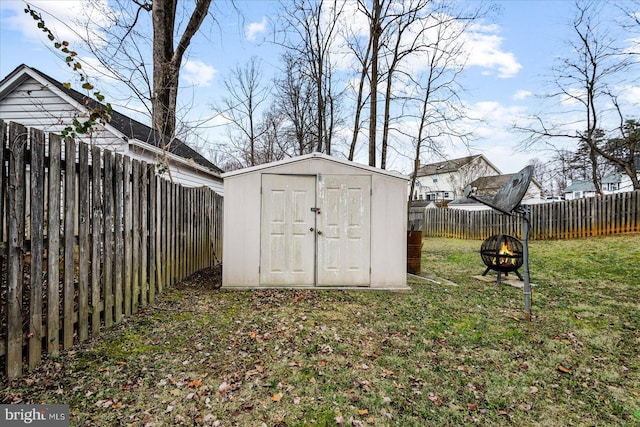 view of outbuilding featuring a fire pit and a lawn