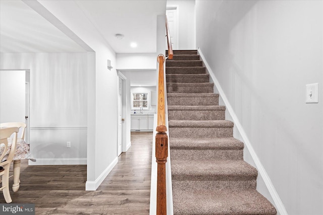 stairs with sink and hardwood / wood-style floors