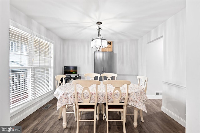 dining space featuring dark hardwood / wood-style flooring and a notable chandelier