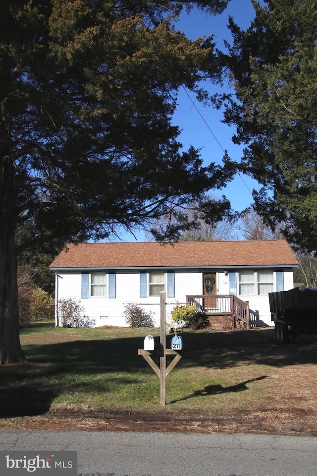 view of front of property with a front yard and a deck