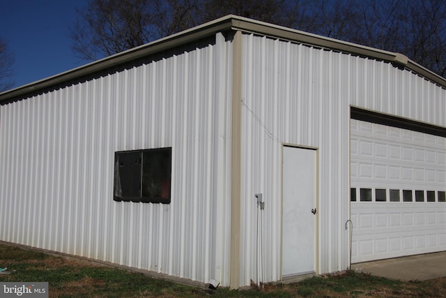 exterior space with a garage and an outbuilding