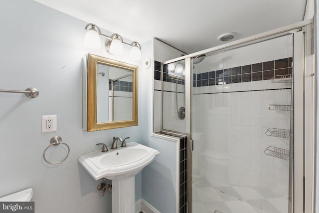 bathroom featuring toilet and an enclosed shower