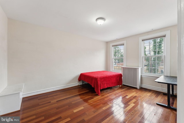 bedroom featuring hardwood / wood-style flooring and radiator