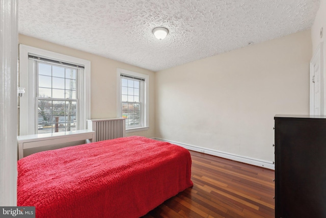 bedroom featuring dark hardwood / wood-style floors and a textured ceiling