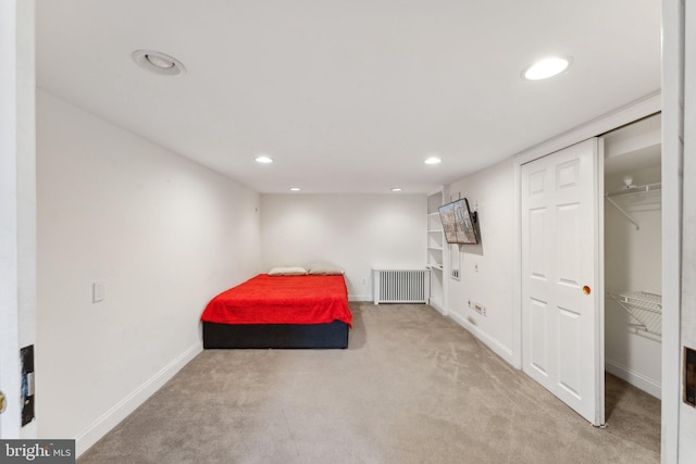 carpeted bedroom featuring a closet and radiator heating unit