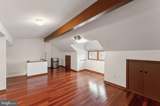 bonus room featuring lofted ceiling with beams and dark wood-type flooring