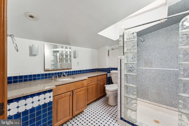 bathroom featuring walk in shower, tile patterned floors, toilet, vanity, and tile walls