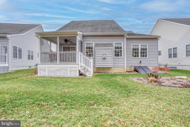 back of property with ceiling fan and a yard