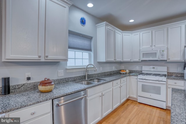 kitchen featuring sink, light stone counters, light hardwood / wood-style floors, white appliances, and white cabinets