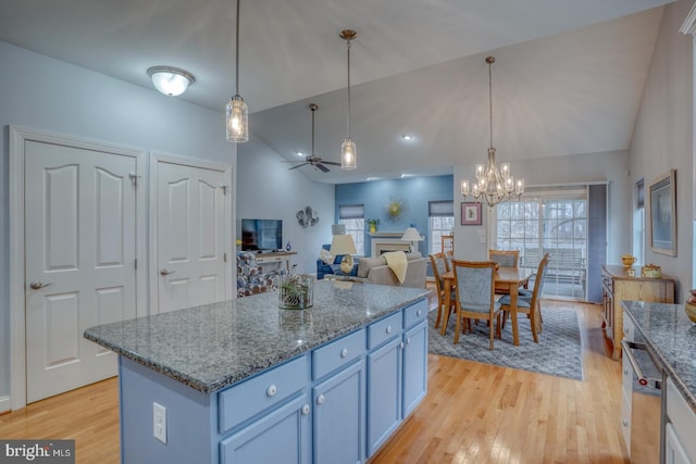 kitchen featuring ceiling fan with notable chandelier, light hardwood / wood-style flooring, hanging light fixtures, and vaulted ceiling