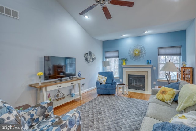 living room featuring hardwood / wood-style flooring, ceiling fan, a wealth of natural light, and vaulted ceiling