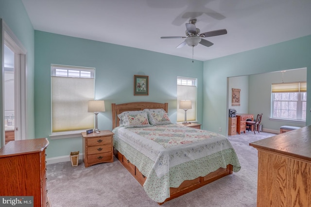 bedroom with multiple windows, light colored carpet, and ceiling fan