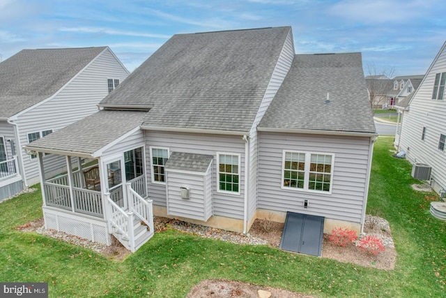 back of house featuring a sunroom, cooling unit, and a yard