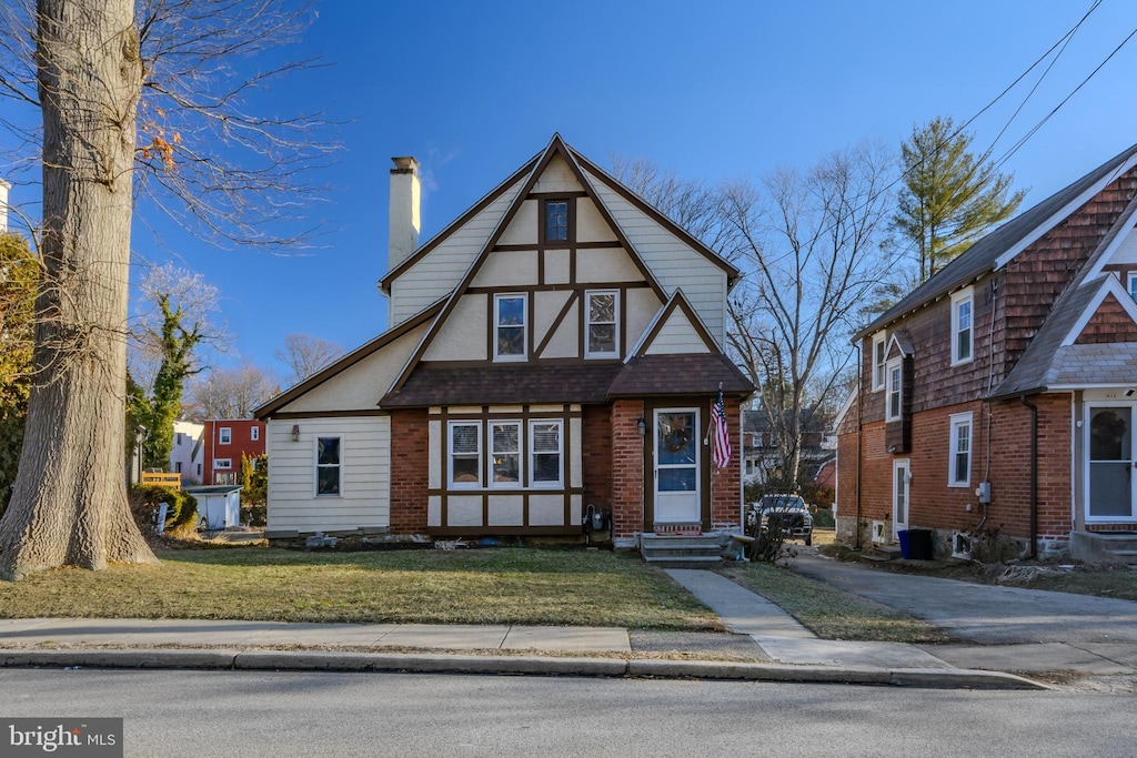 tudor home featuring a front lawn