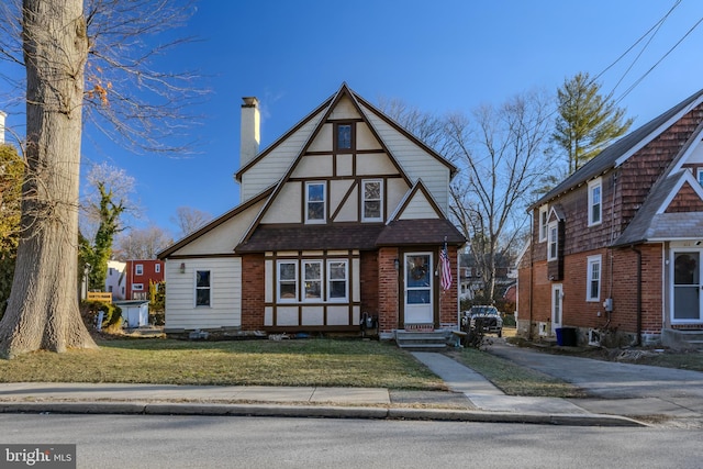 tudor home featuring a front lawn