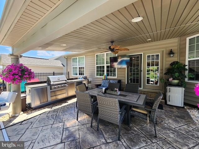 view of patio with outdoor dining area, ceiling fan, an outdoor kitchen, and area for grilling