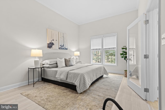 bedroom with baseboards, light wood-style floors, and crown molding