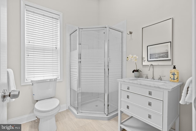 full bath featuring baseboards, toilet, a shower stall, and vanity