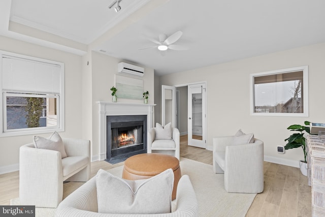 living room with light wood-style floors, a fireplace with flush hearth, a wall unit AC, and baseboards