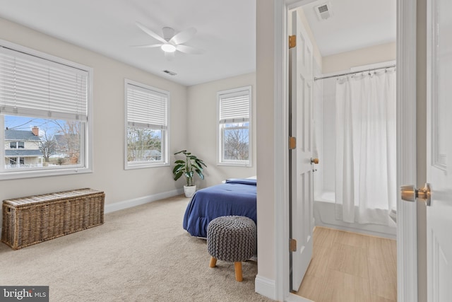 bedroom with light carpet, baseboards, visible vents, and a ceiling fan