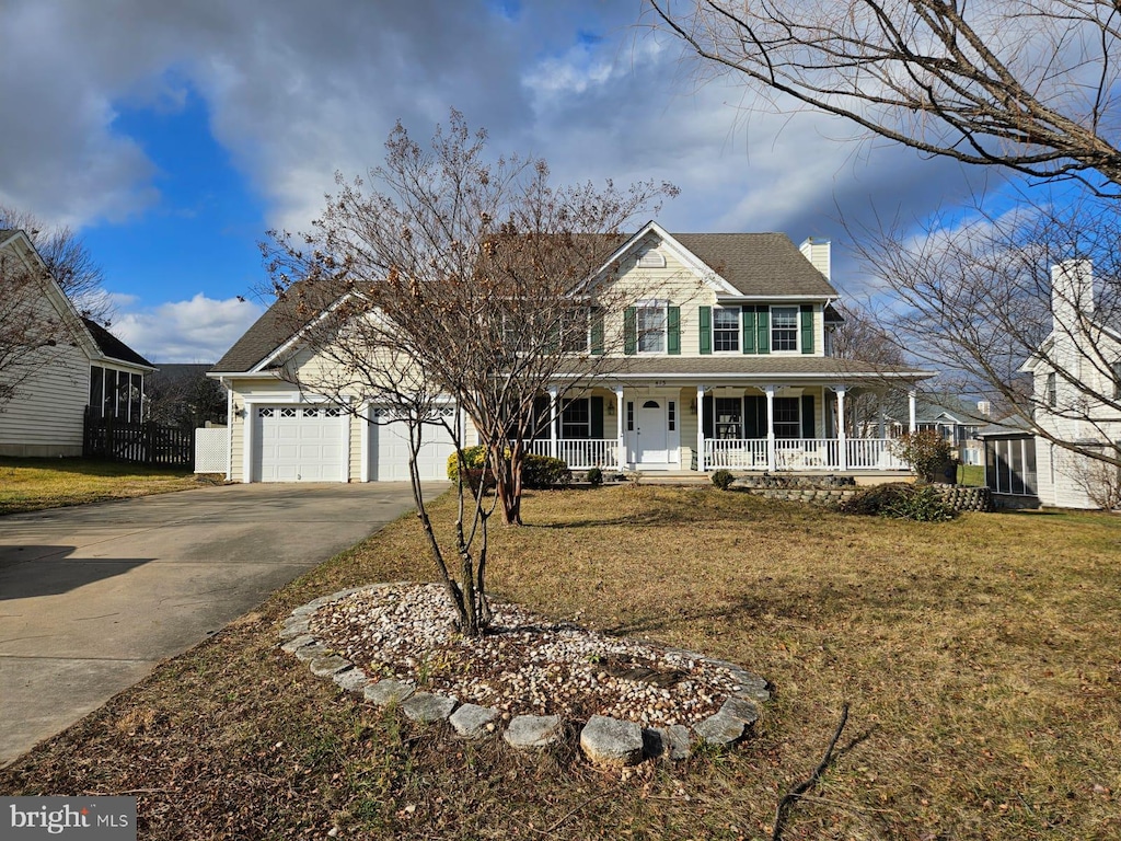 view of front of property with a front yard, covered porch, and a garage