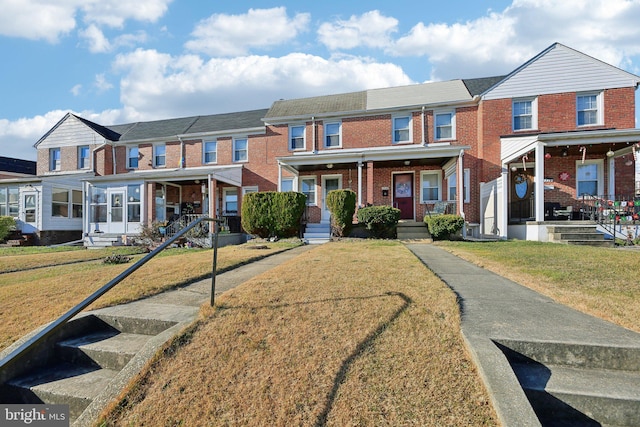 townhome / multi-family property with a front yard and a porch