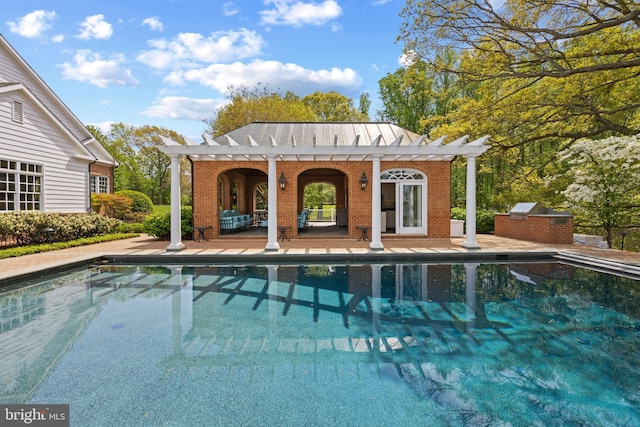 pool with an exterior structure, a patio, an outdoor structure, an outdoor kitchen, and a pergola