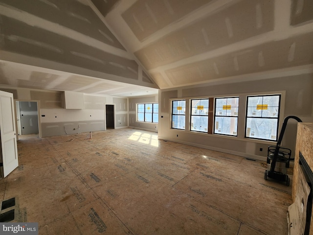 unfurnished living room featuring vaulted ceiling and a fireplace