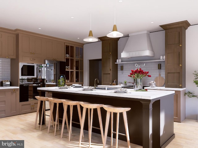 kitchen with custom exhaust hood, backsplash, a spacious island, and decorative light fixtures